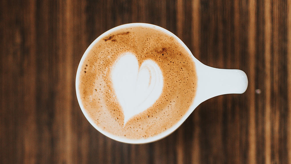 Afbeelding van een koffiekopje van bovenaf met een hartje in de crème laag
