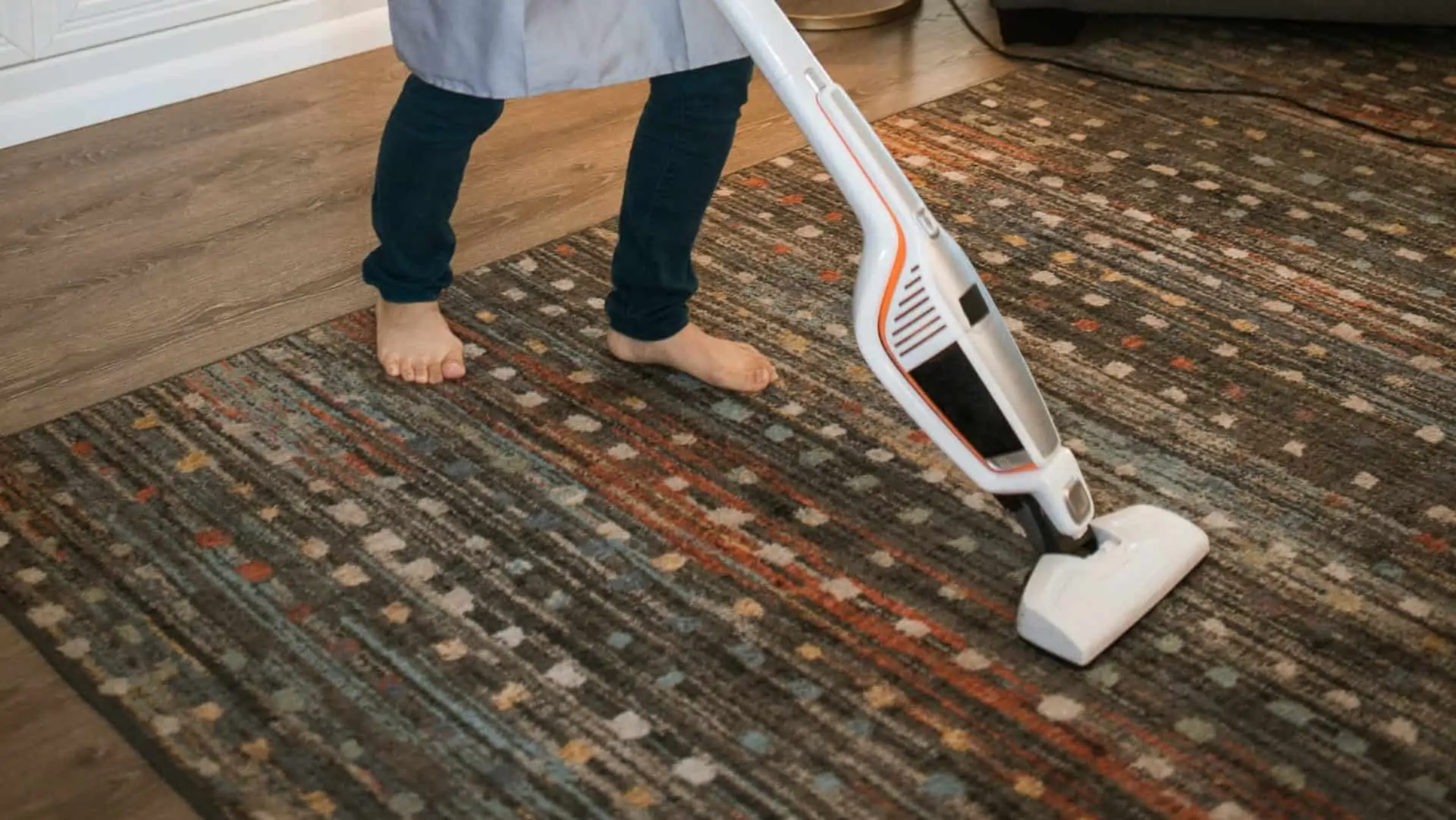 Persoon stofzuigt tapijt.