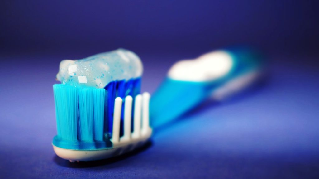 Tandenborstel met tandpasta op blauwe achtergrond
