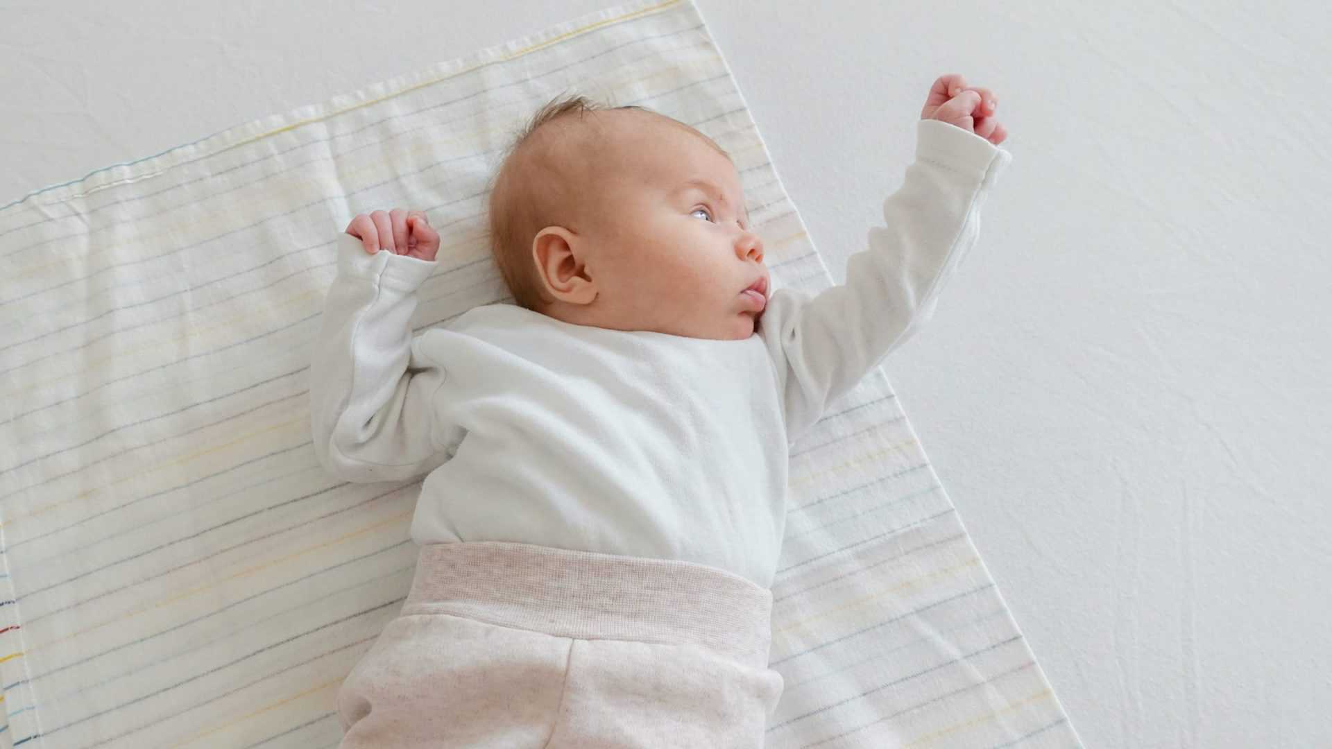 Afbeelding van een baby op een kleedje.