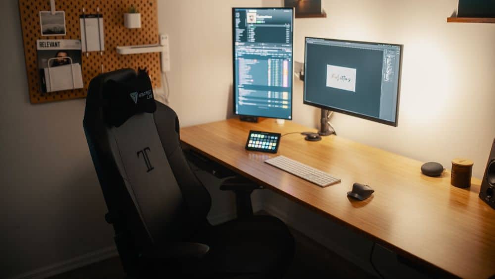 Secretlab stoel voor houten bureau met twee monitors
