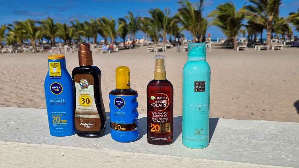 Flesjes zonnebrand met een strand en palmbomen op de achtergrond.